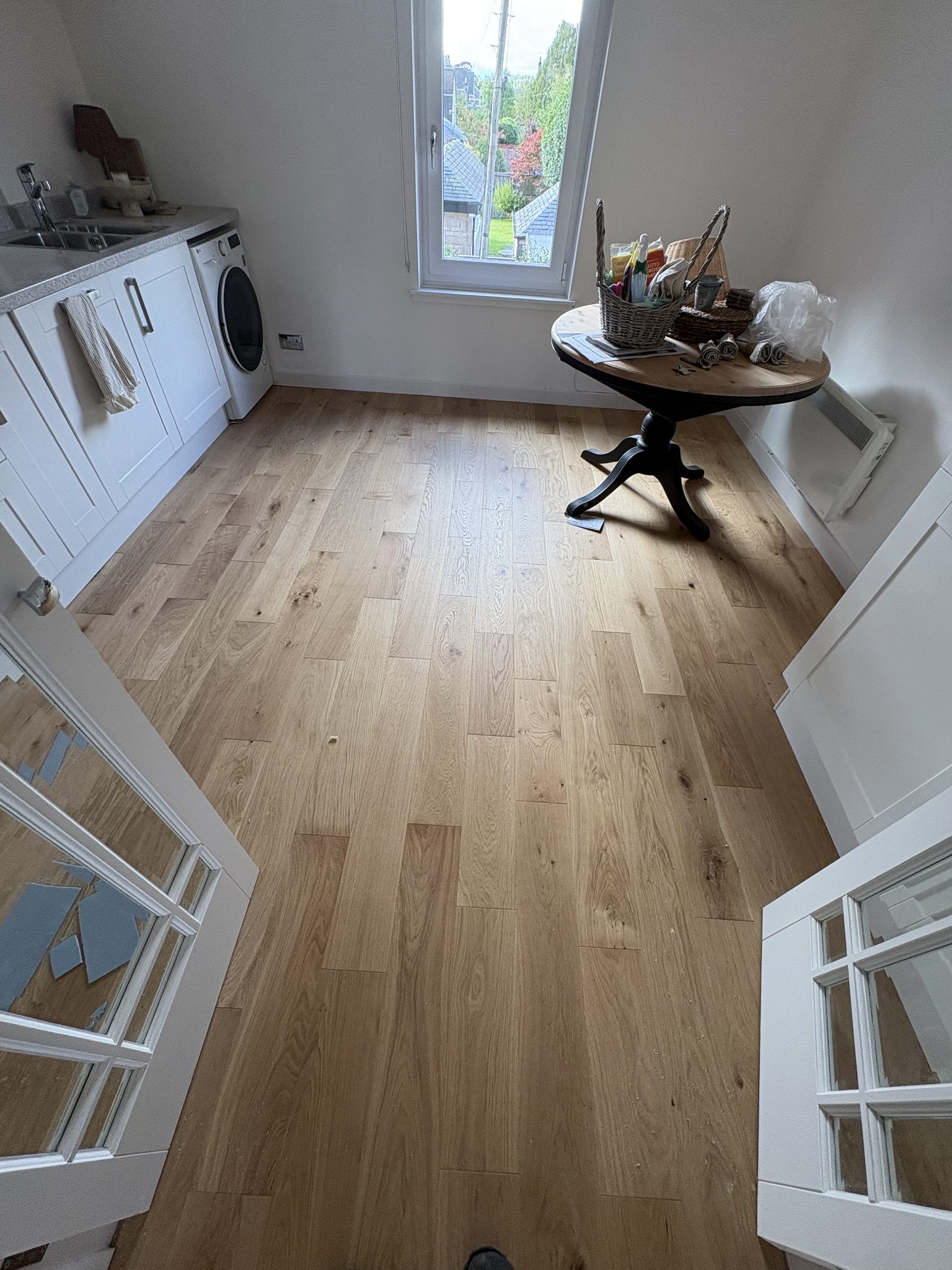 Kitchen in Bridge of Allan with engineered hardwood flooring laid up to the white units and the glazed doors