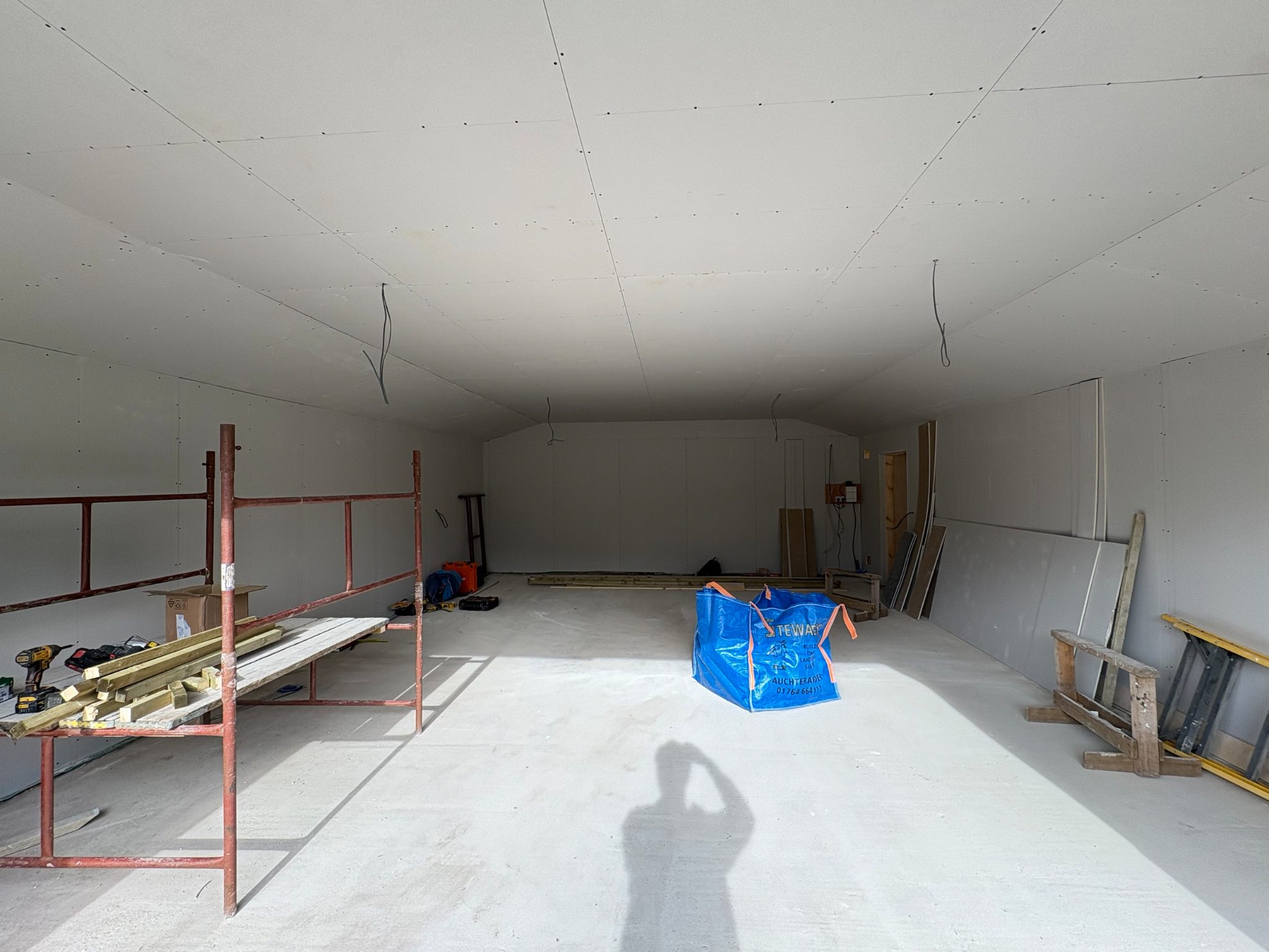 Interior of the garage at Auchterarder with the walls and ceiling lined out in plasterboard over the concrete floor