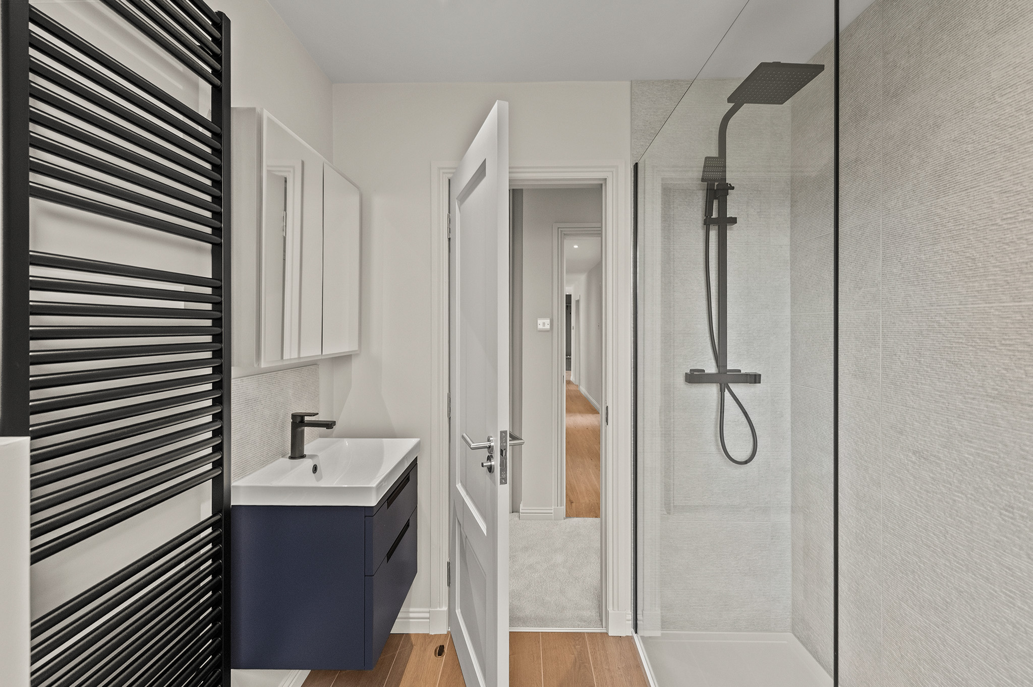 Shower room at Auchterarder with a walk in shower, navy vanity unit and heated towel rail