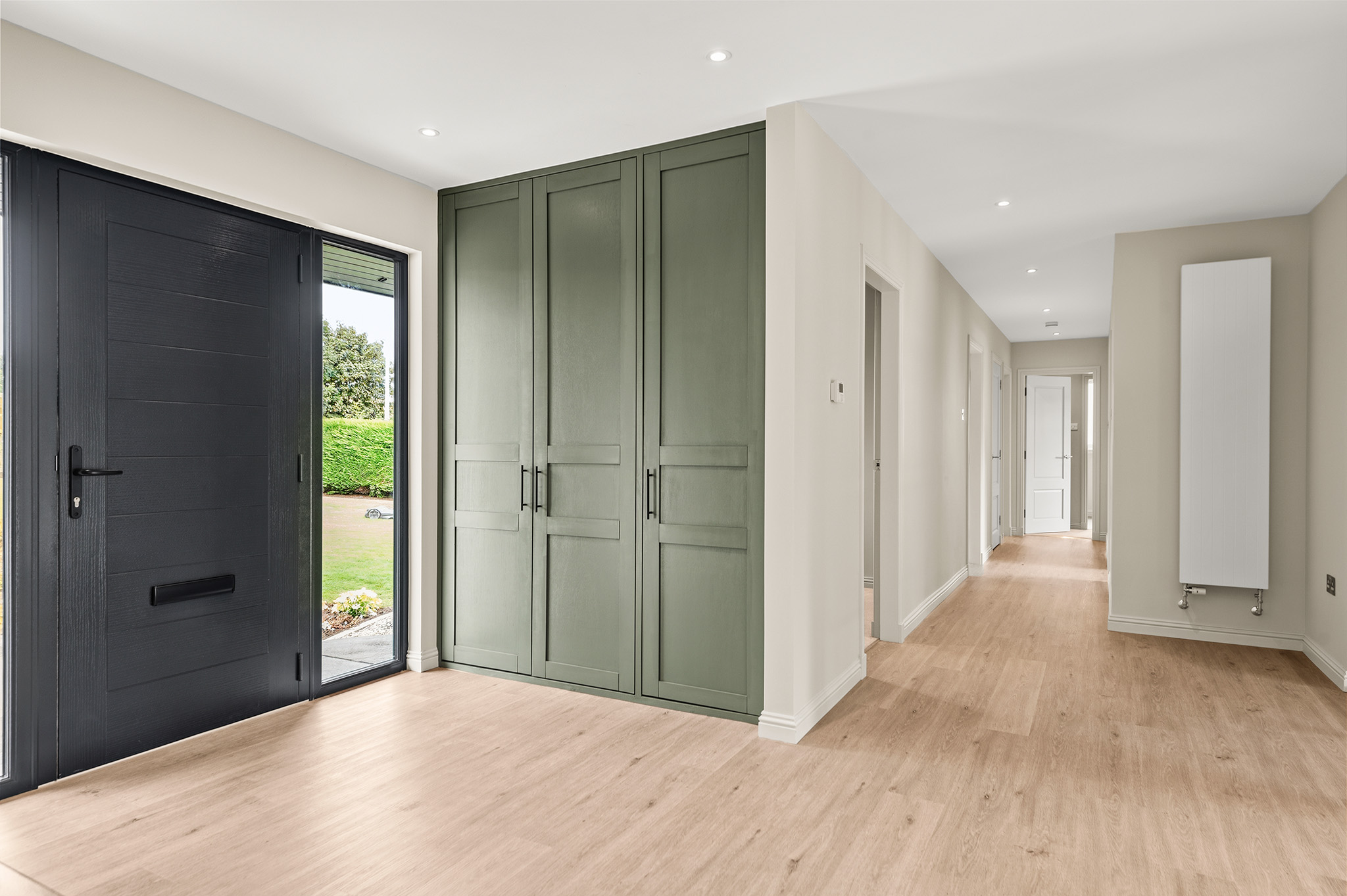 Entrance hall at Auchterarder with a dark composite front door and fitted sage green storage