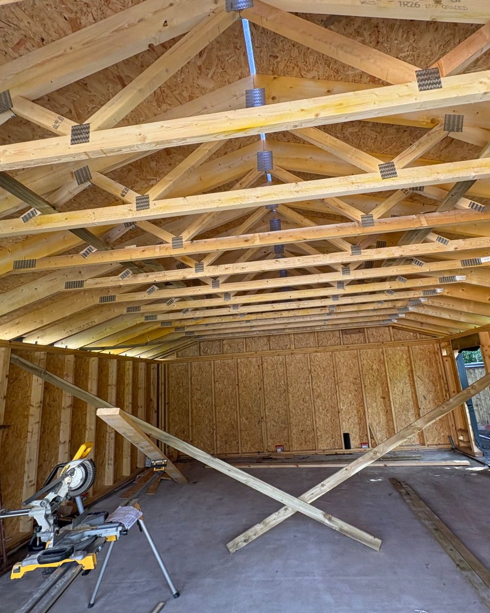 Inside a garage under construction in Perthshire: timber roof trusses over a sheathed timber frame